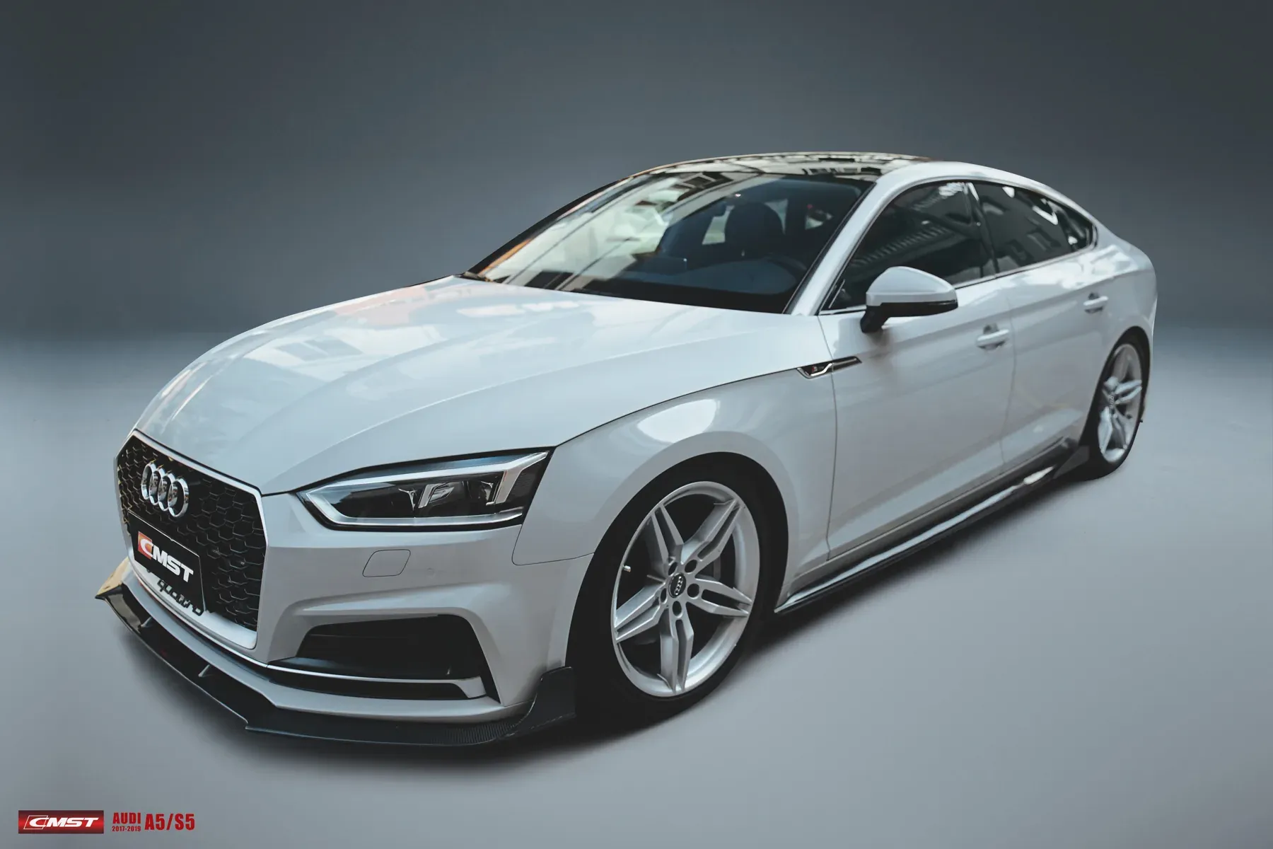 White Audi A5 with a CMST carbon front lip and side skirts fitted, photographed in the studio