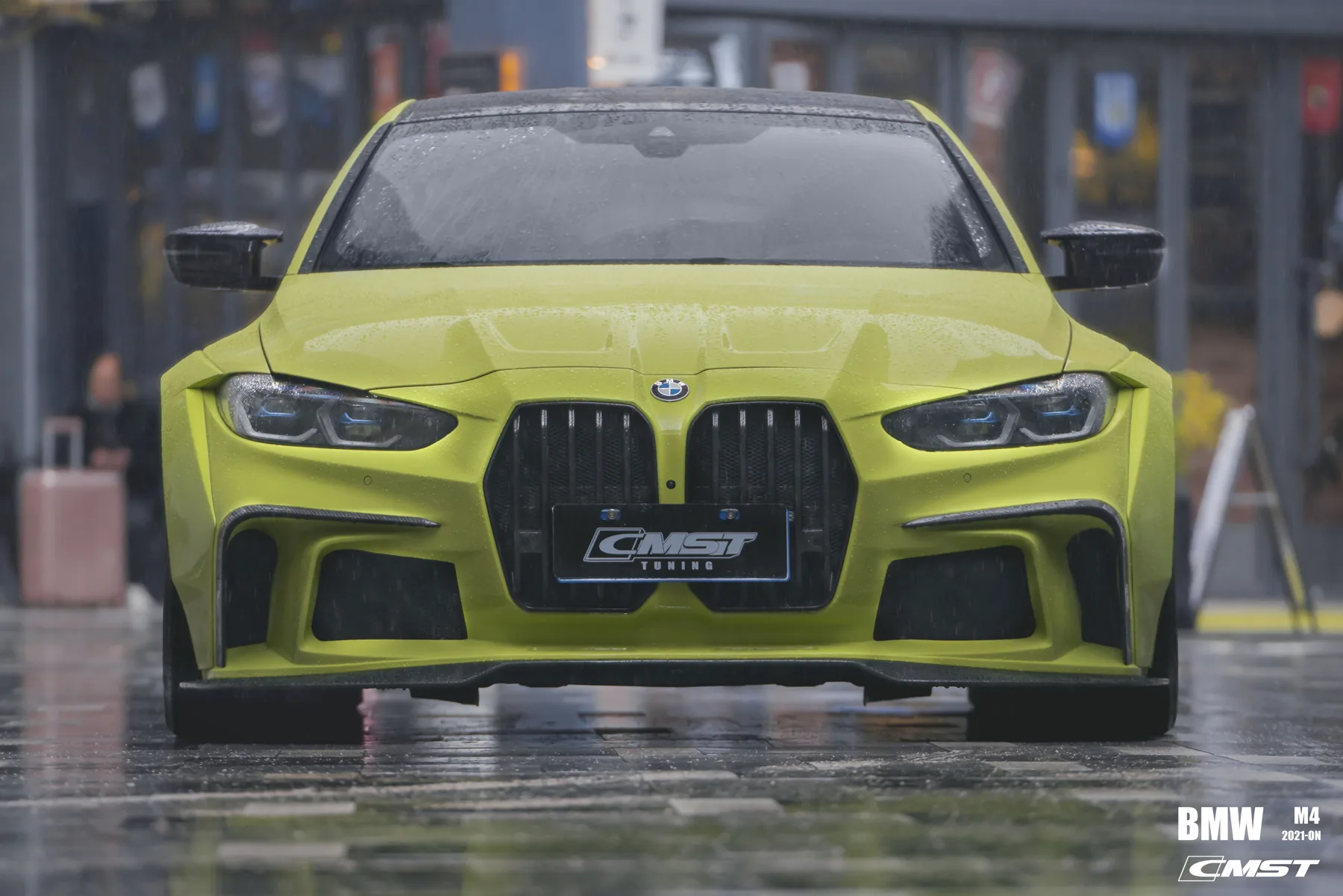 Front end of a yellow BMW M4 G82 with a black grille, a dark front lip and a body-color hood