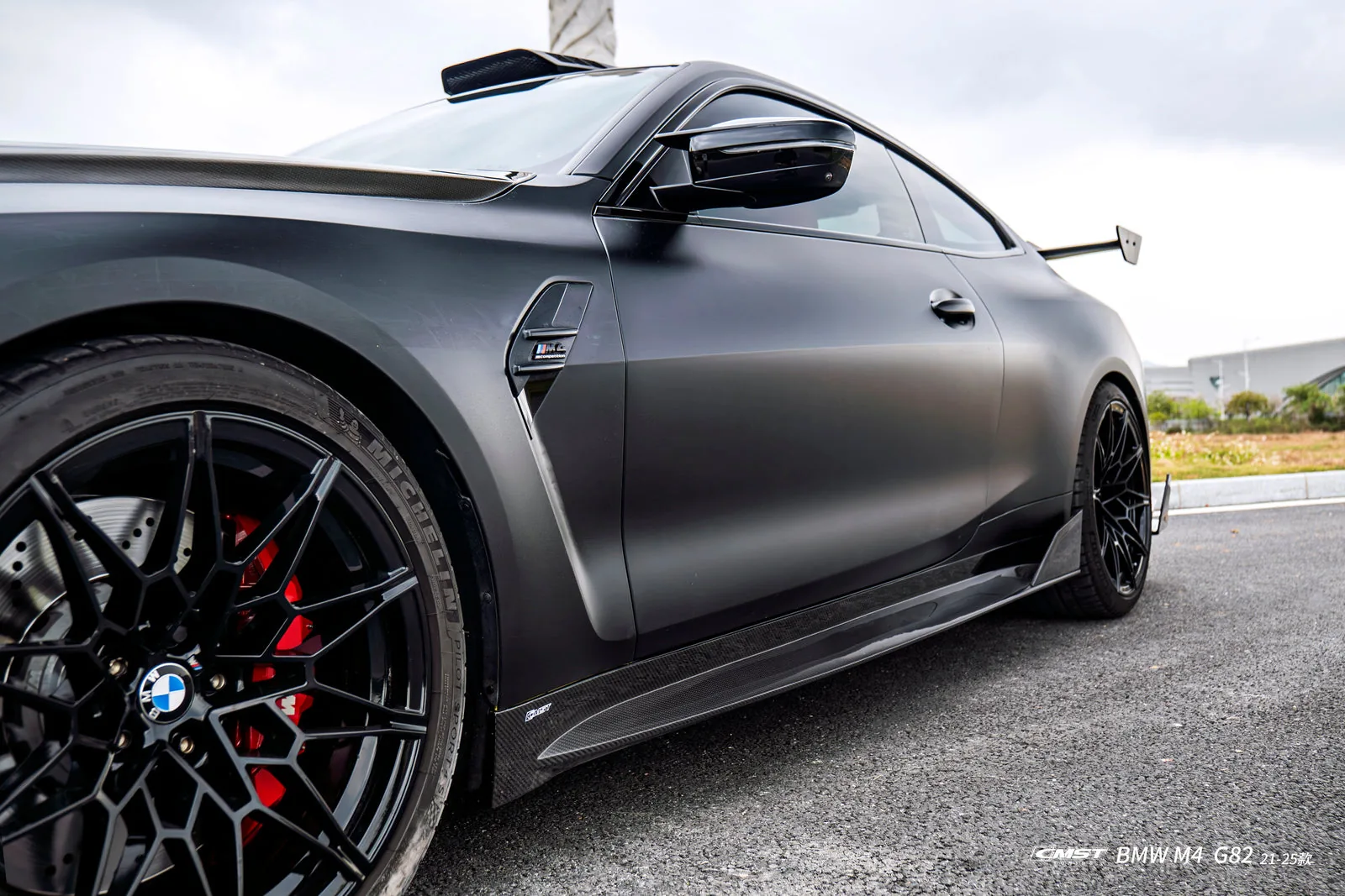 Matte black BMW M4 G82 side view showing the widened front arch, side skirt and deep-dish wheel